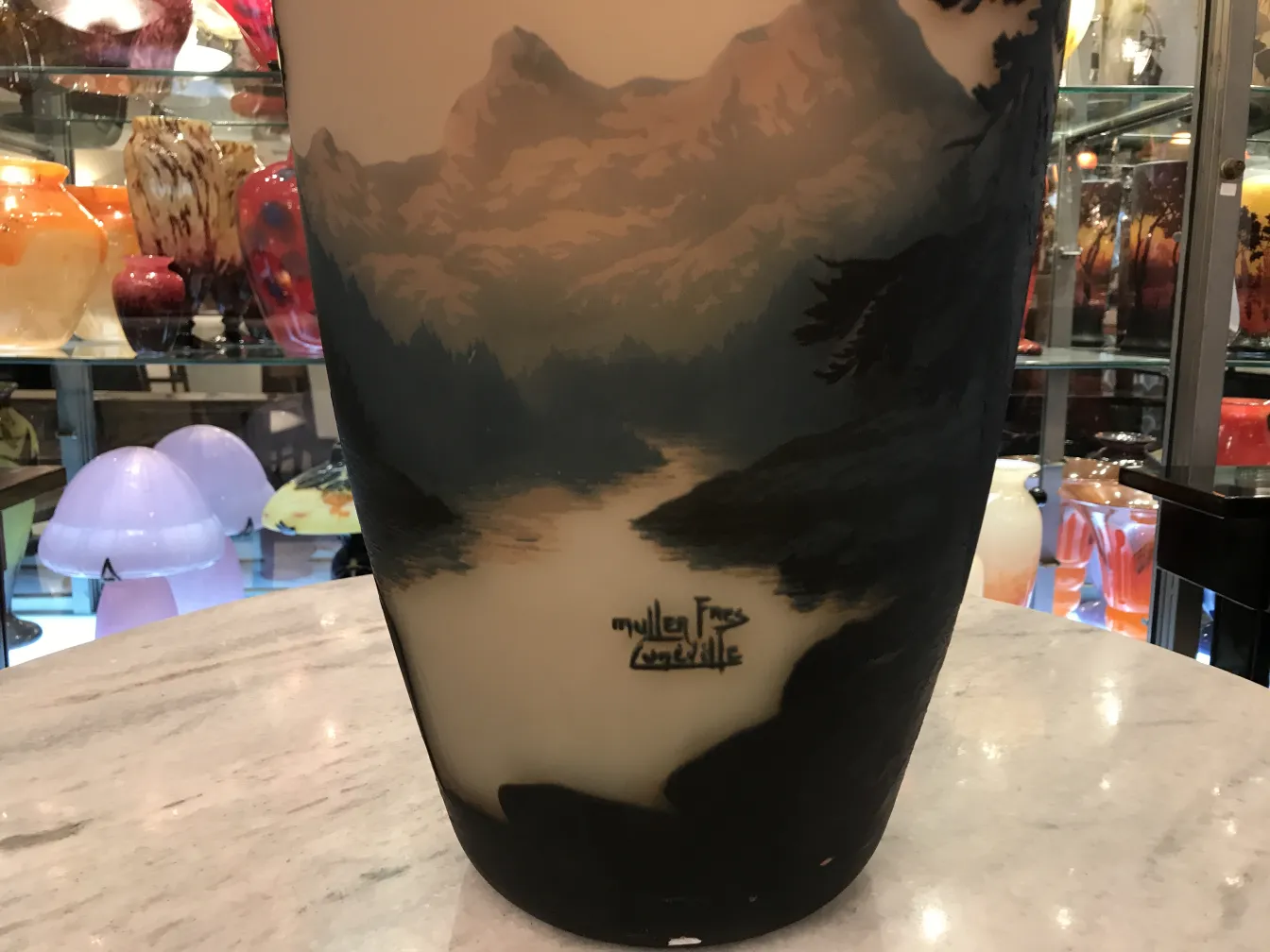 Vidro assinado antigo Muller Fres com relevo de paisagens e fundo decorativo.