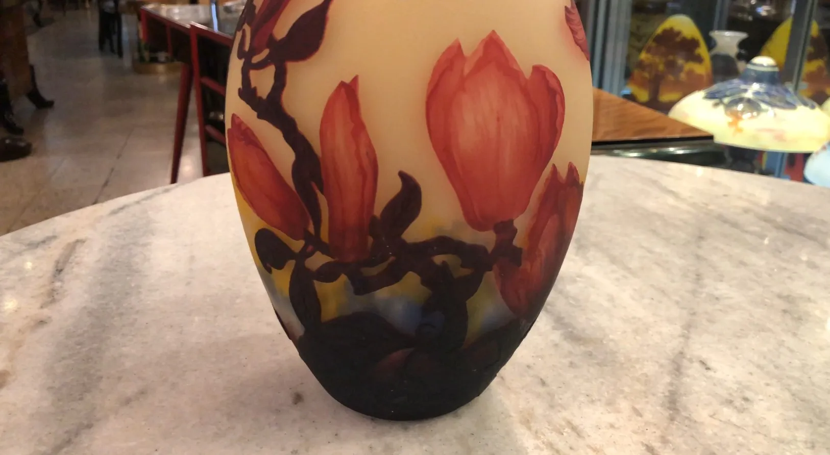 Vaso antigo com flores vermelhas, assinado por Muller Fres, design clássico elegante.