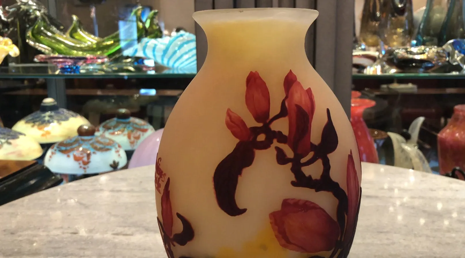 um elegante vaso de vidro com design floral em cores quentes, assinado por muller fres