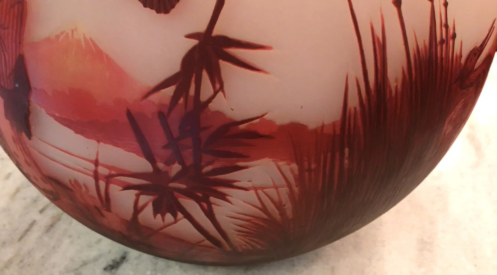 Vidro antigo assinado por Muller Fres, com detalhes em vermelho e paisagem natural.