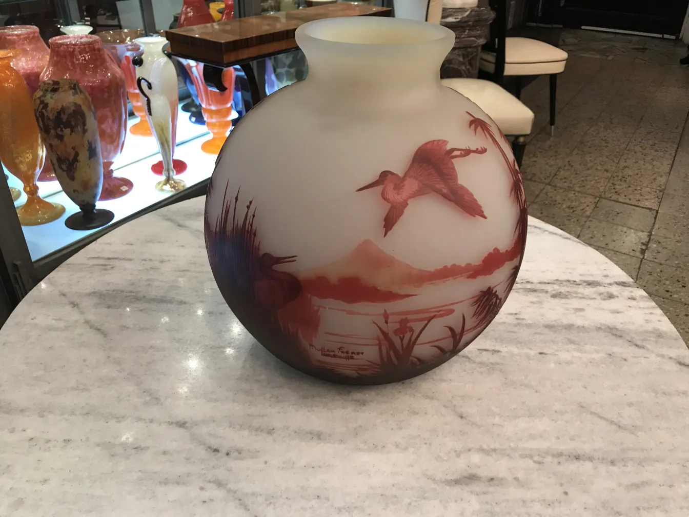 vaso de vidro antigo com design de pássaros em ambiente natural