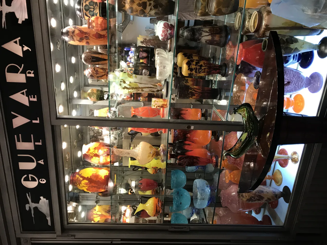 Vidro assinado por Muller Fres, com cores vibrantes em uma vitrine.