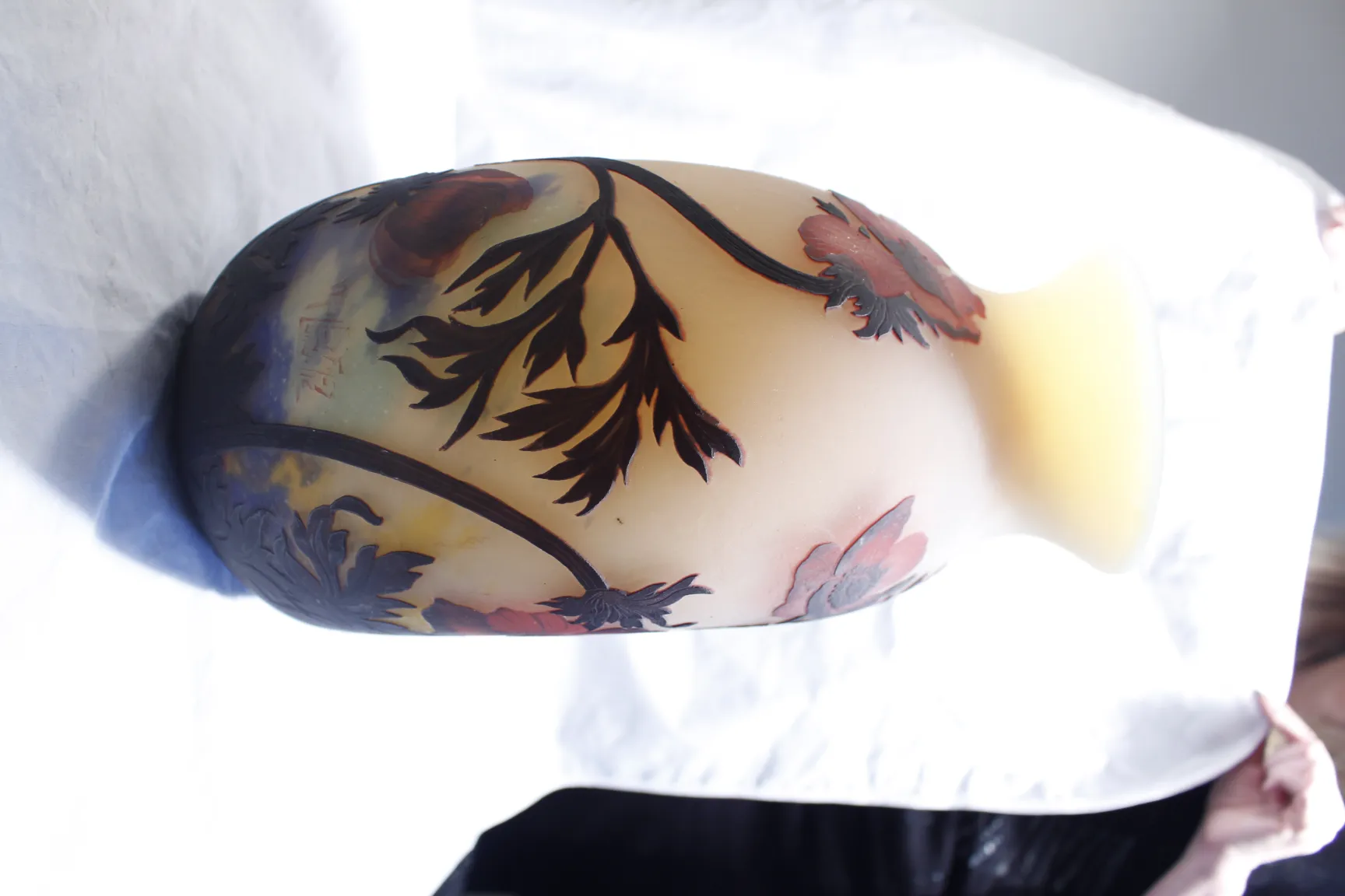 Vidro assinado Muller Fres com design floral antigo, fundo suave.