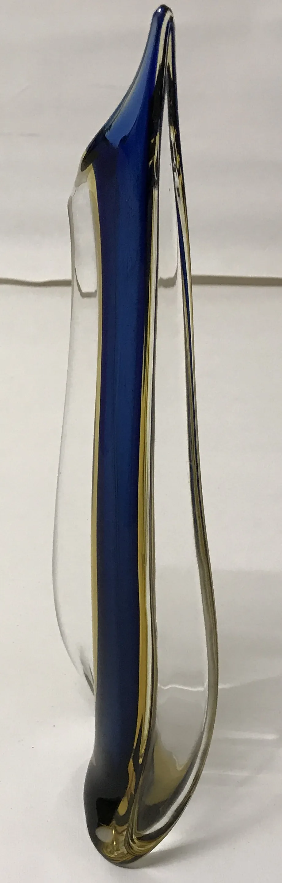 Murano vase with wavy design in blue and clear colors on a neutral background.