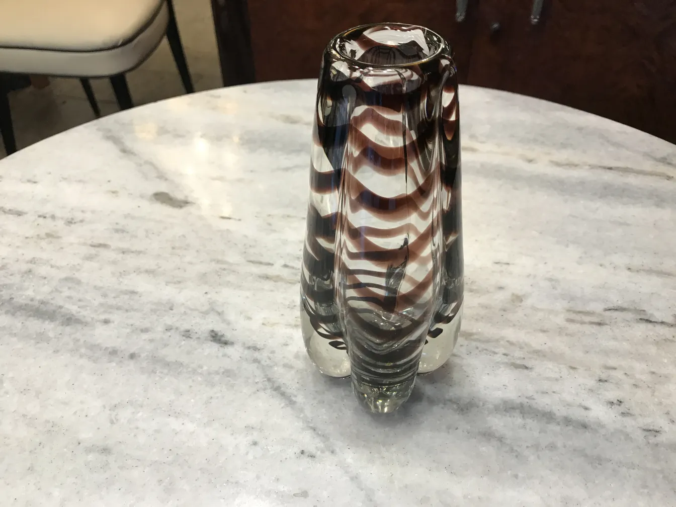 antique murano vase with wavy design in brown and clear tones on marble table