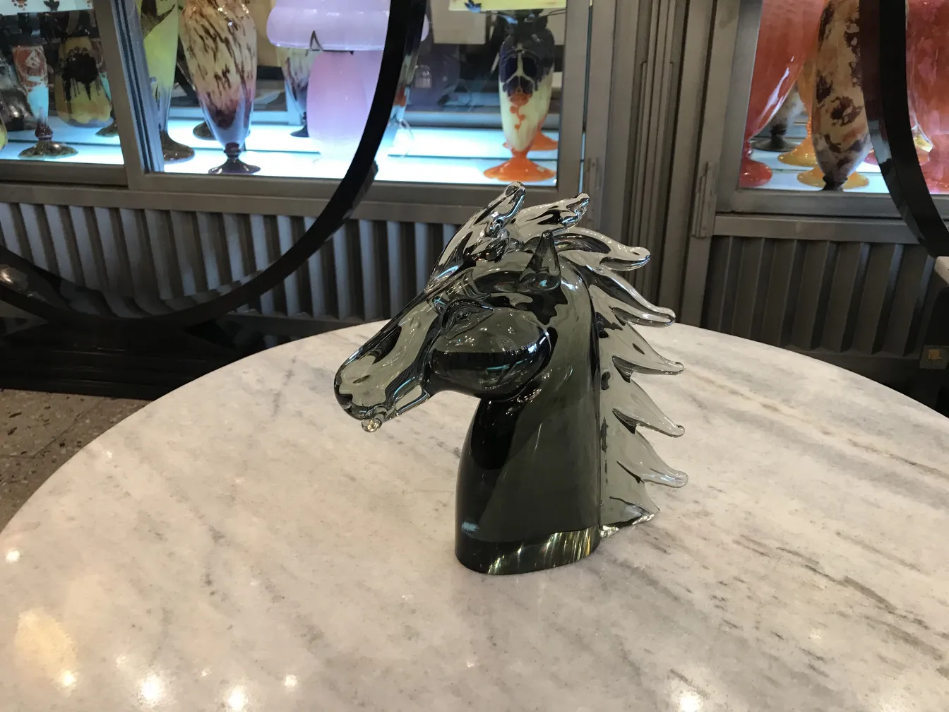 antique Murano sculpture shaped like a horse head on a marble table