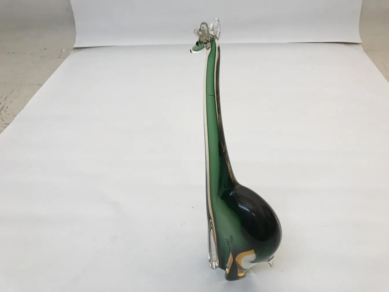 antique murano sculpture featuring a giraffe design in green and black colors