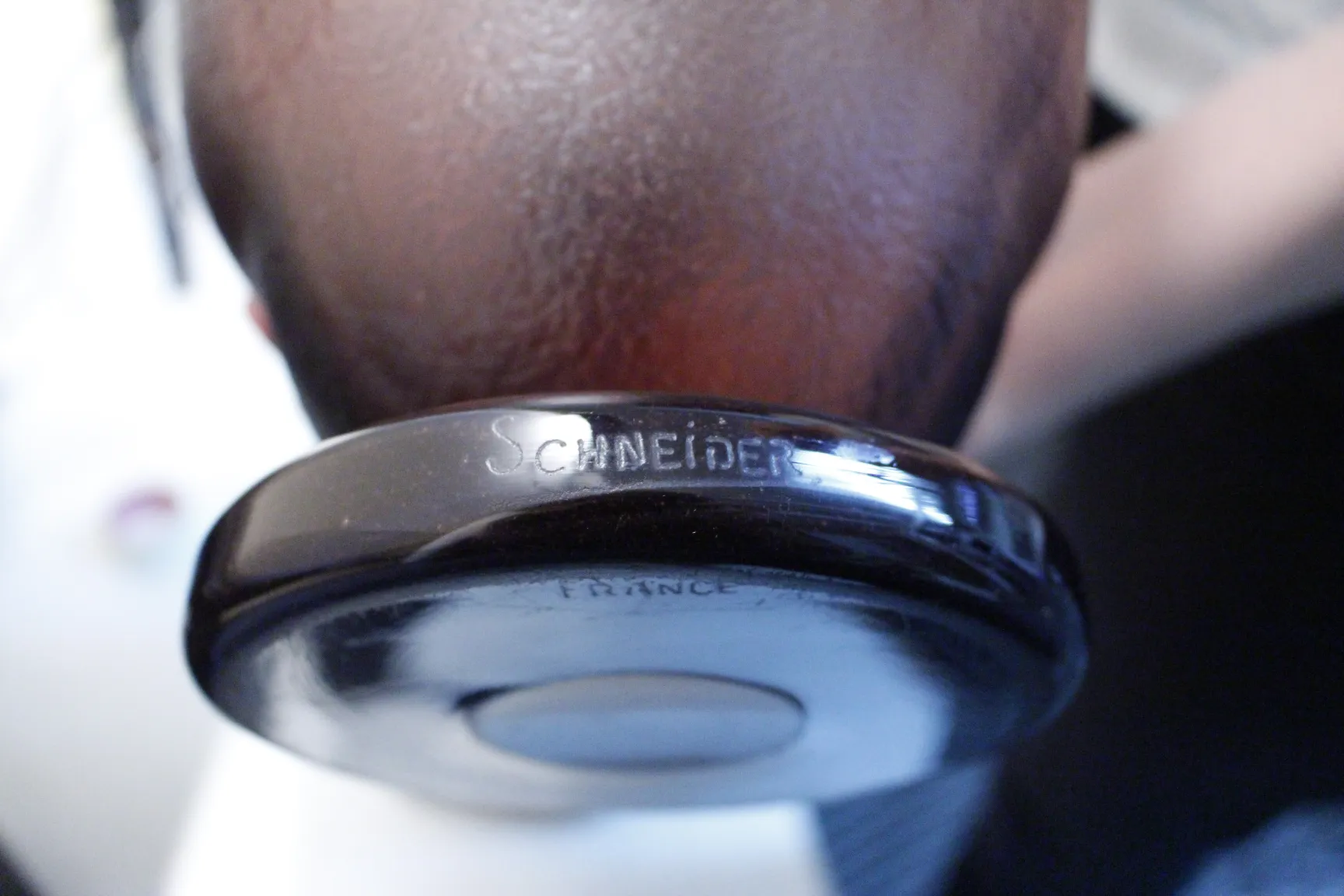 슈나이더의 서명이 있는 고전적인 유리잔, 어두운 받침, 단순한 환경.