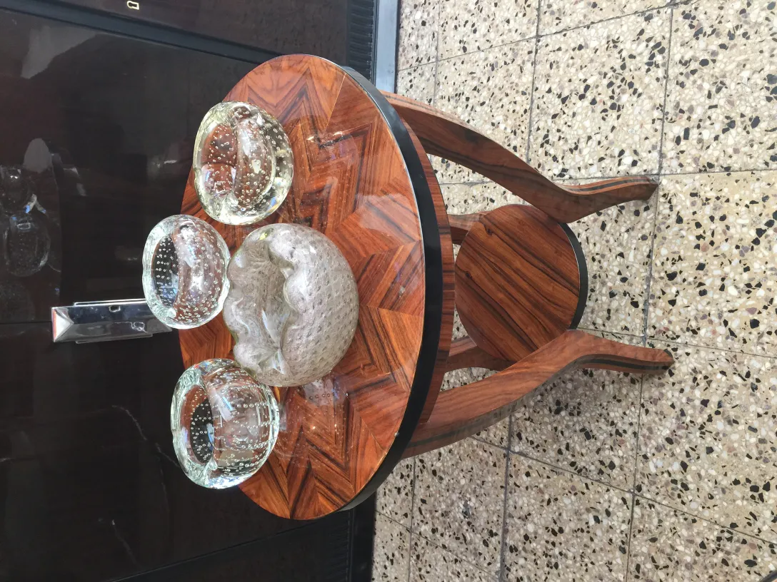 three pieces of Murano glass on a wooden table