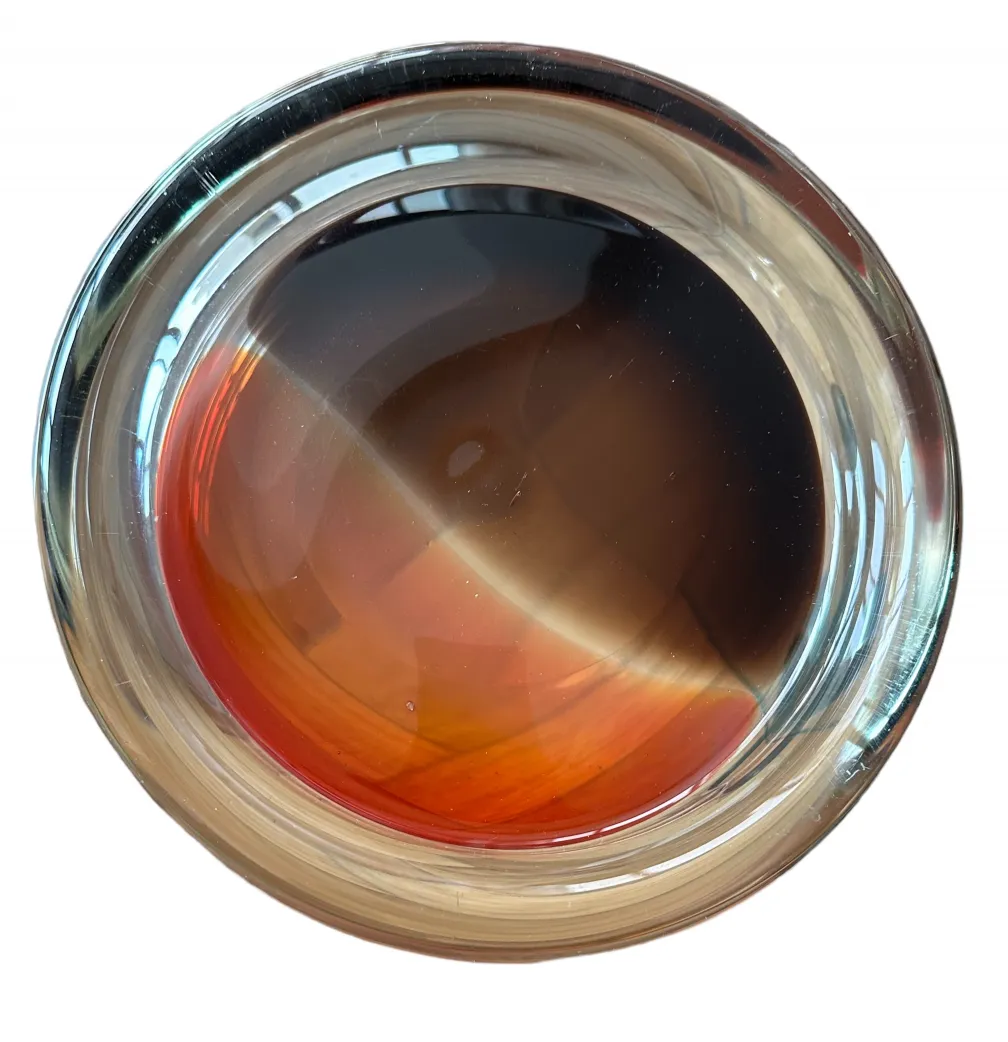 Beautiful Murano glass with warm tones and artisan quality in a circular shape.