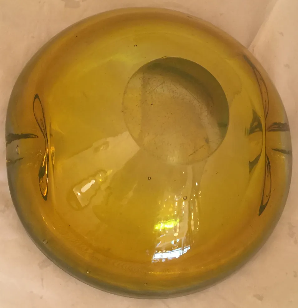 Old yellow Murano glass orb with subtle design.