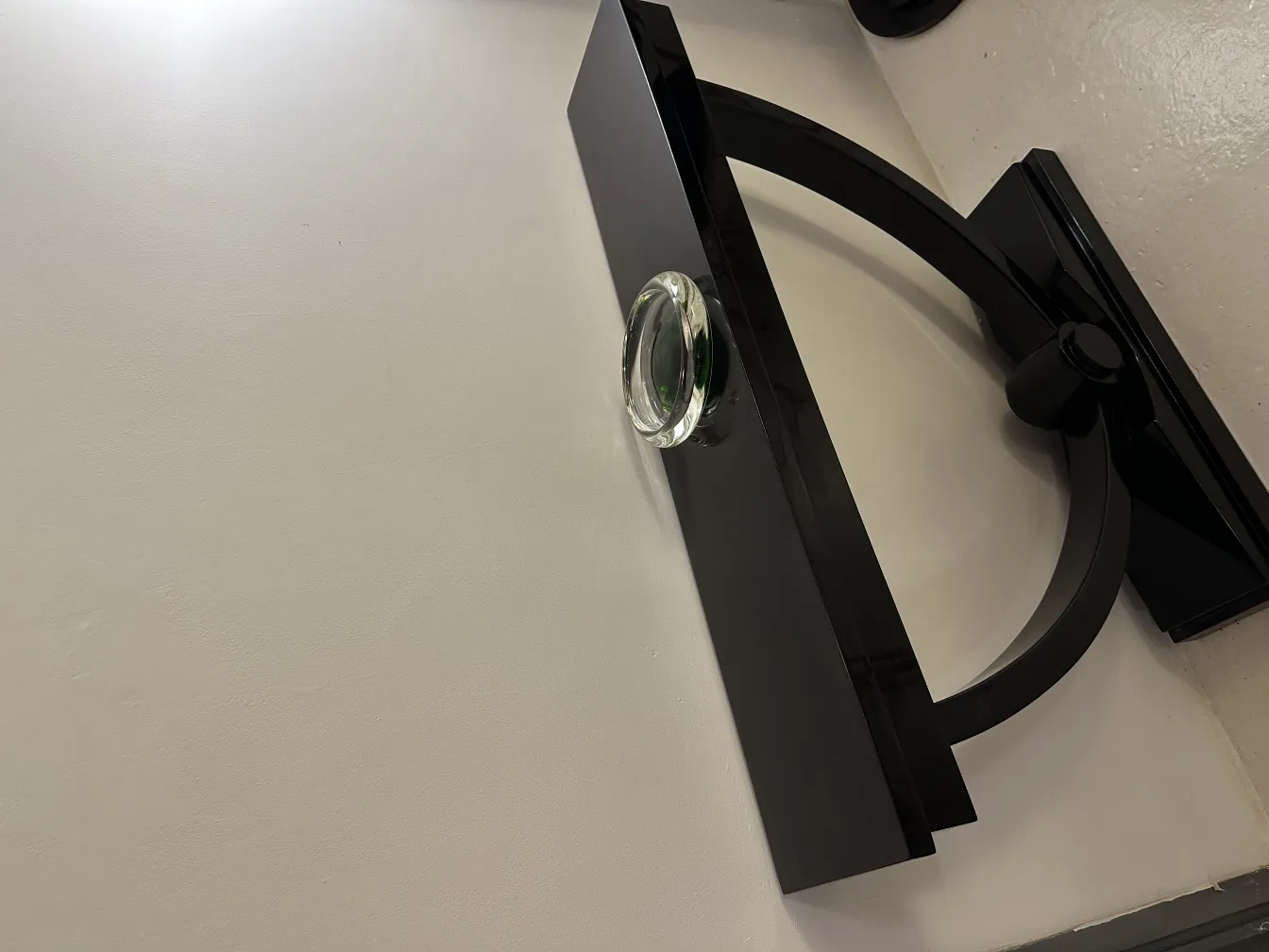 Antique Murano glass on a modern black stand atop a light surface.