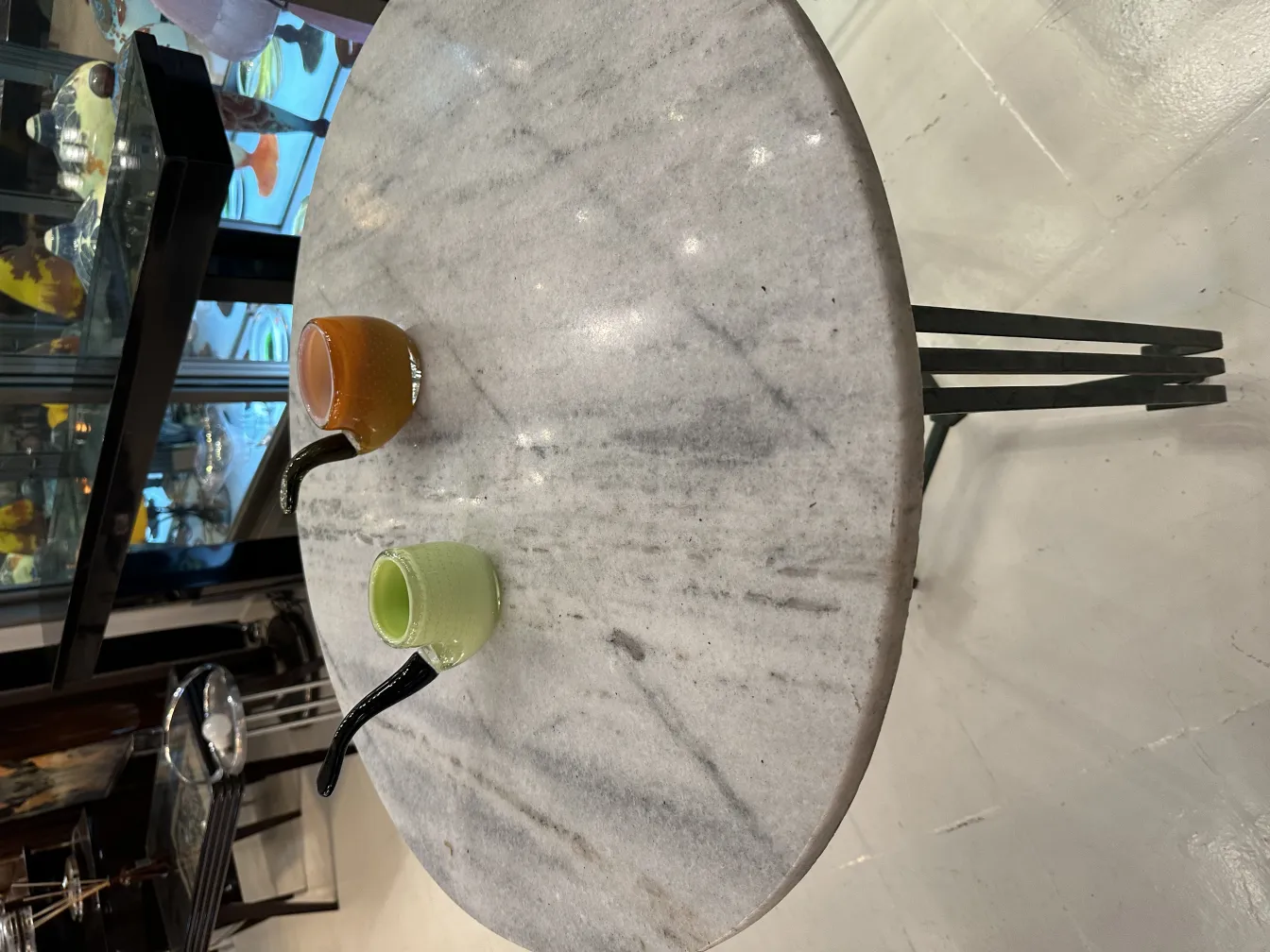 Two small antique Murano glass pieces on a marble table.