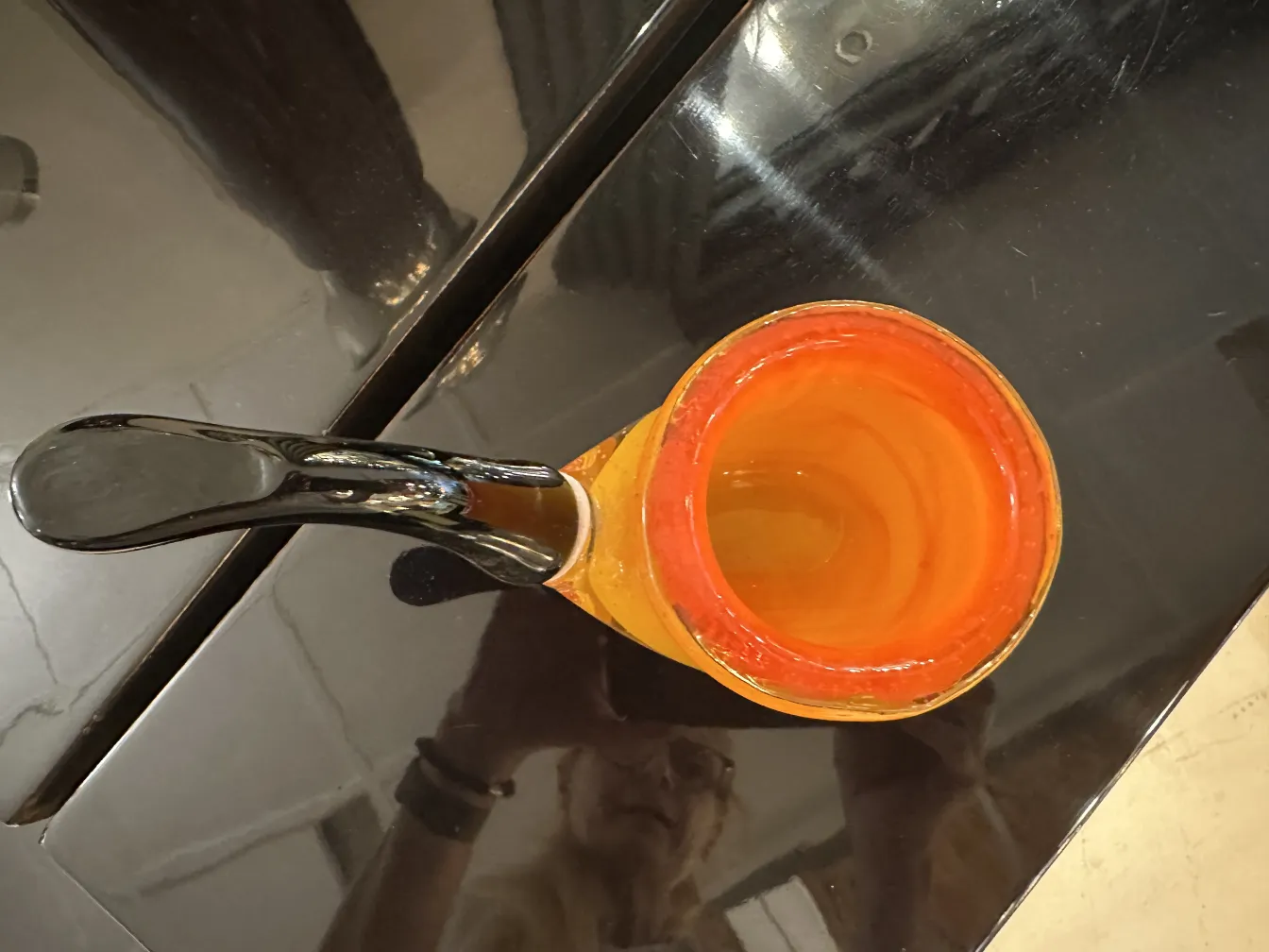 Antique Murano glass with vibrant colors and unique shape on dark surface.