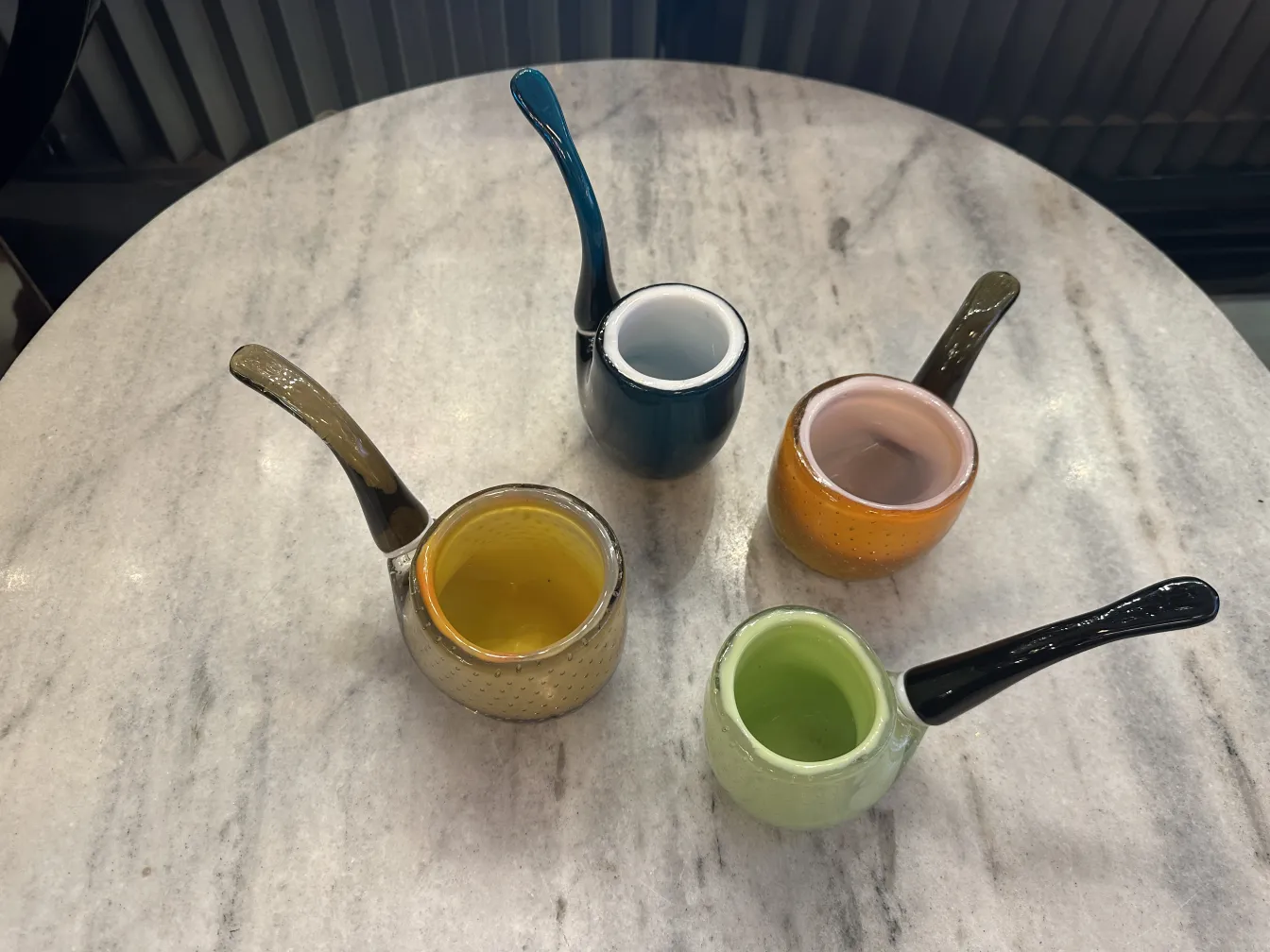 Set of 5 small murano glass containers in various colors on table