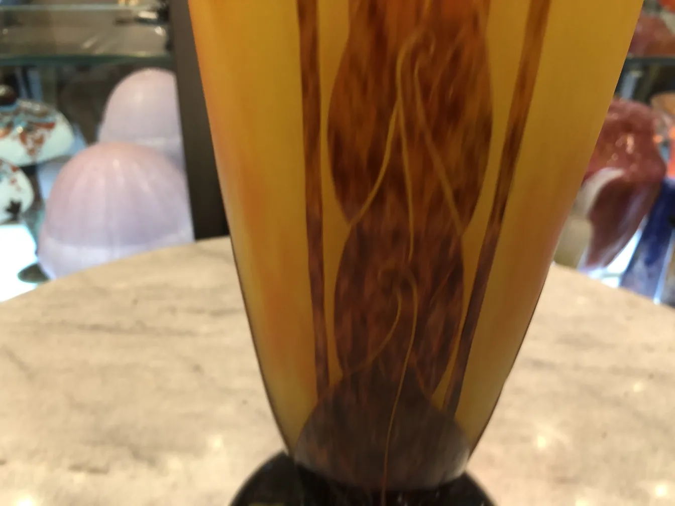 View of antique signed glass featuring amber tones with subtle details.