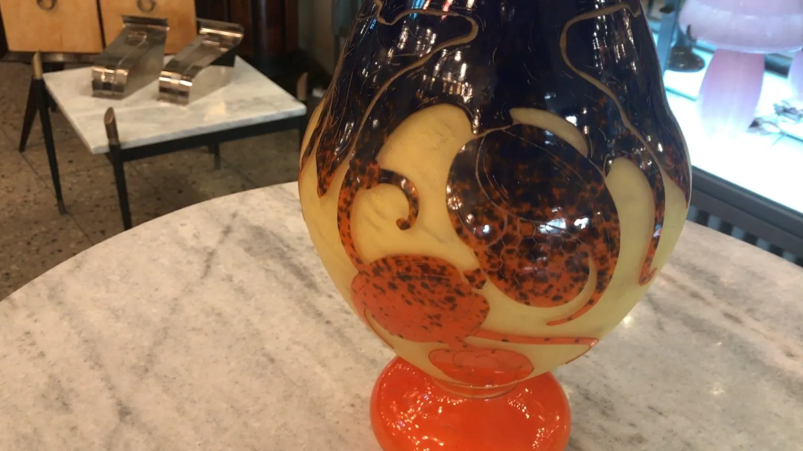 Decorative signed glass with a colorful, stylized design.