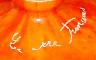 Antique glass with visible signature from le verre french on orange background.