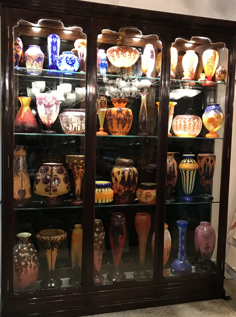 showcase of antiques with various signed glass objects.