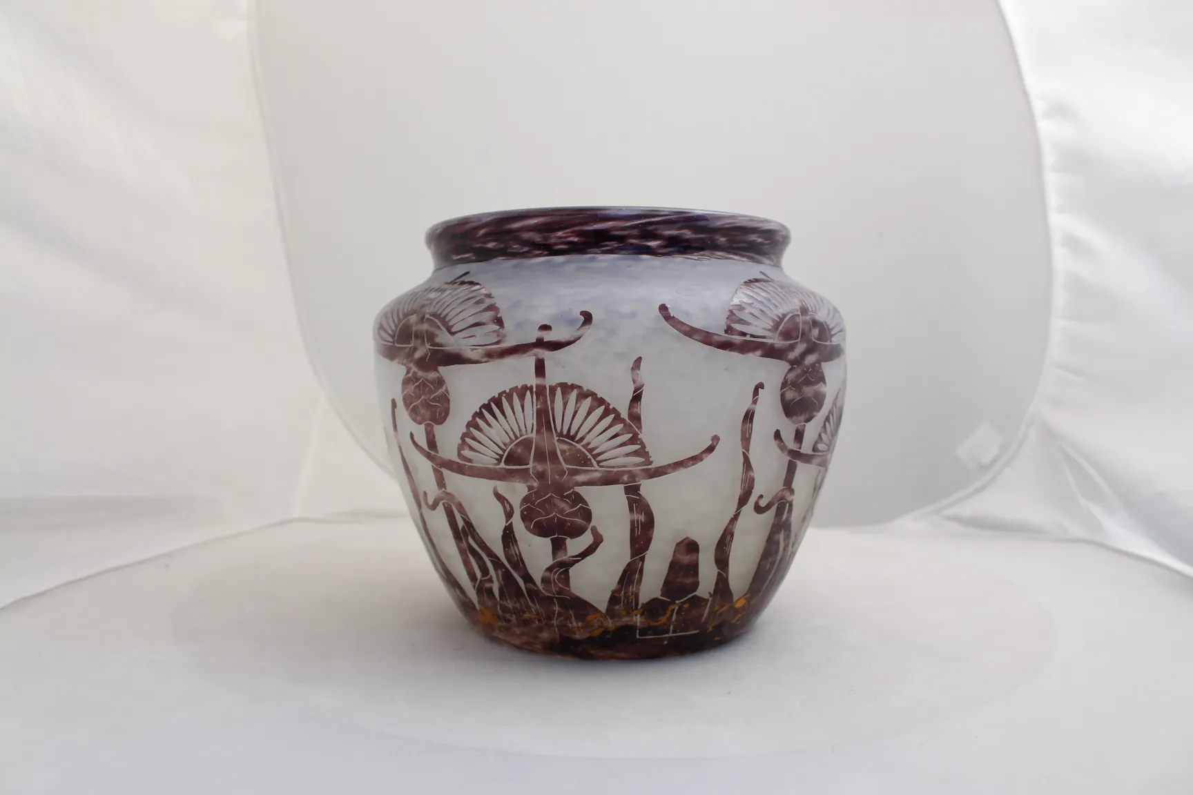 Antique glass jar with engraved design, neutral background.