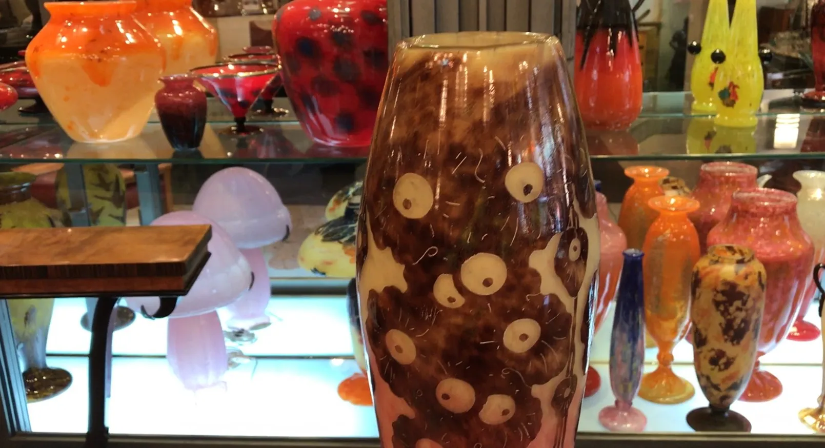 Decorative signed glass vase Le Verre among other colorful items.