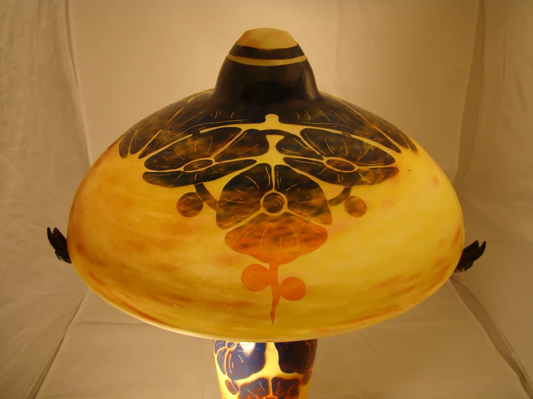 Decorative glass lamp with floral design in brown and yellow shades.