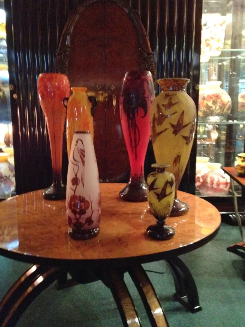 Antique signed glass Le Verre with colorful decorations displayed on an elegant table.