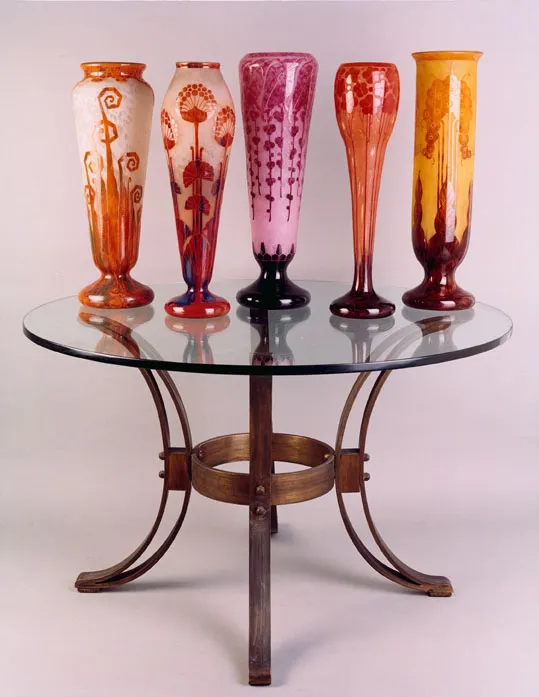 Set of antique glass vases arranged on a round table.