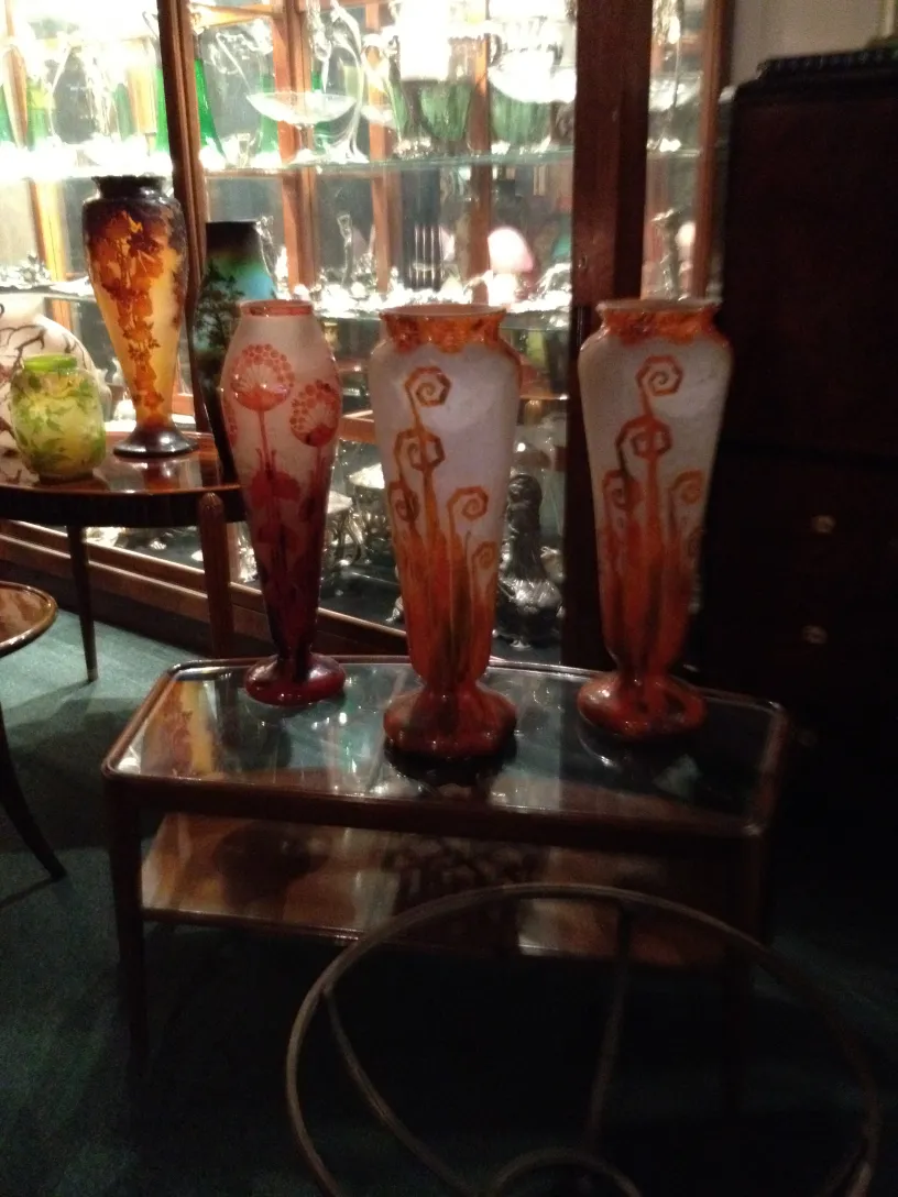 Three antique signed Le Verre glass vases on display.