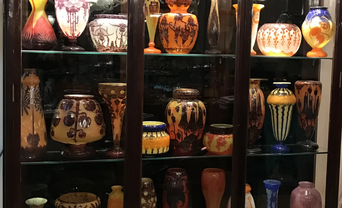 Showcase with antiques, including signed glass Le Verre