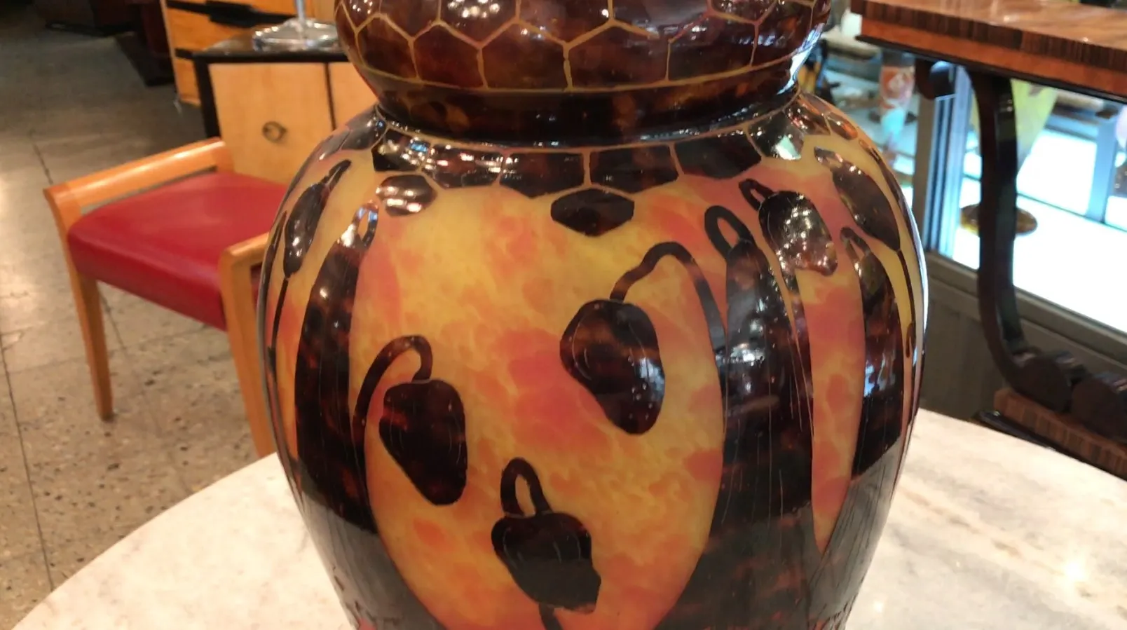 Antique signed glass Le Verre with colorful design, artistic details, and blurred background.