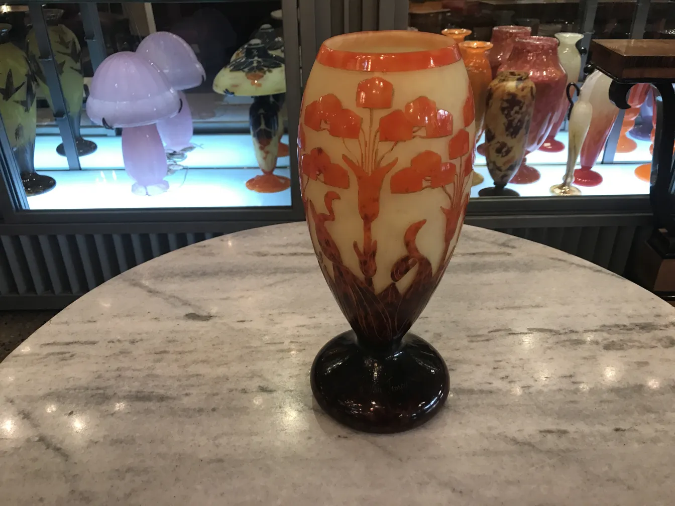 Antique glass with floral design in orange hues displayed.