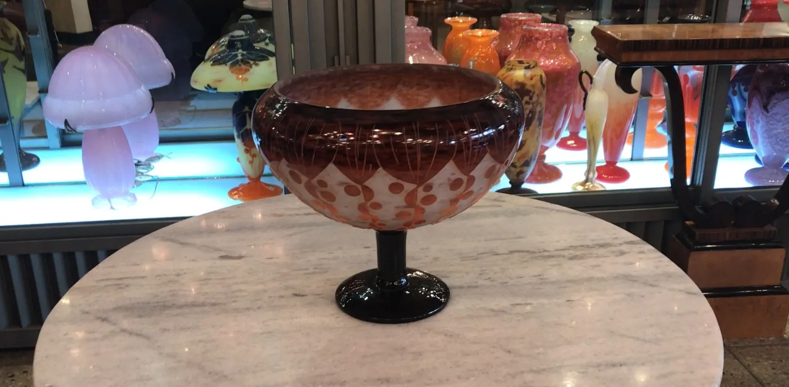 Antique signed glass Le Verre displayed with various decorative items.