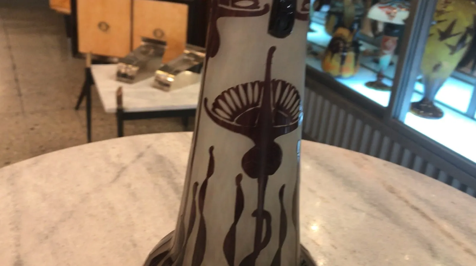 Signed Le Verre glass with elegant dark decoration, antique shop backdrop.