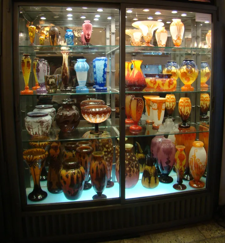showcase with antiques of signed glass Le Verre in various colors and shapes