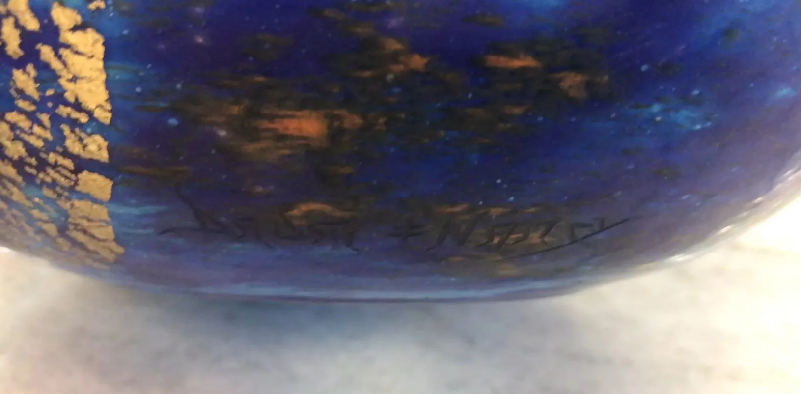 ग्लास पर हस्ताक्षरित डुम नैंसी, जीवंत रंग और सुनहरी विवरण के साथ।