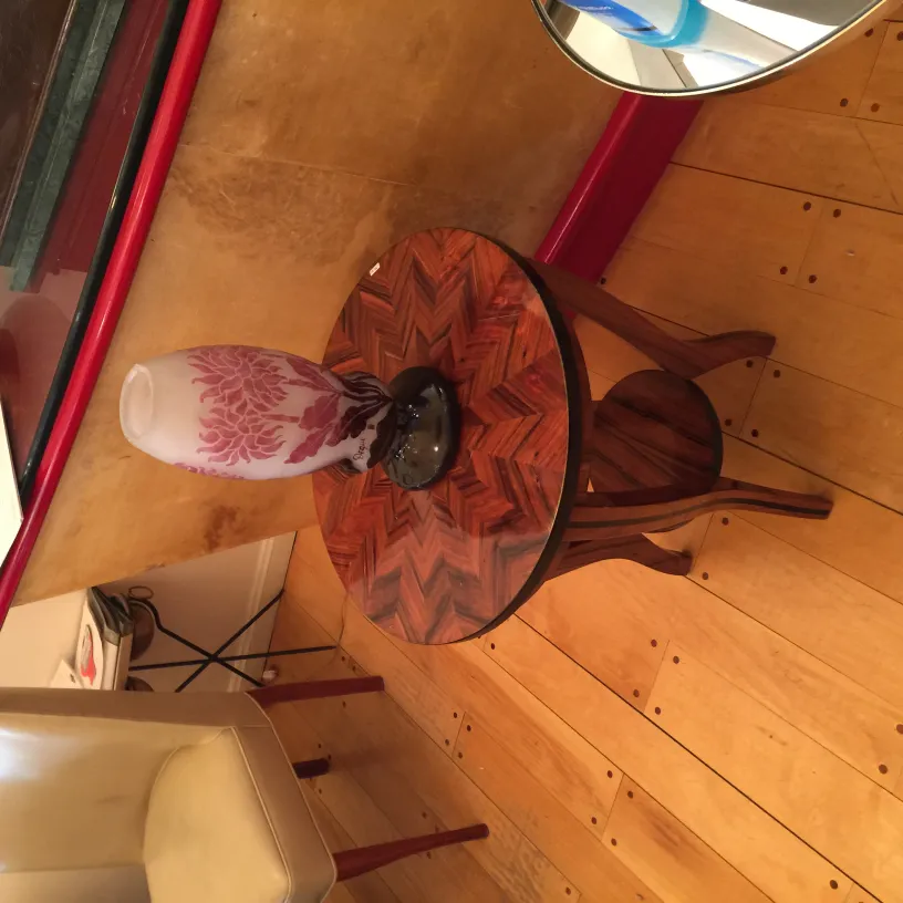 Vidro assinado Degué sobre mesa com decoração floral