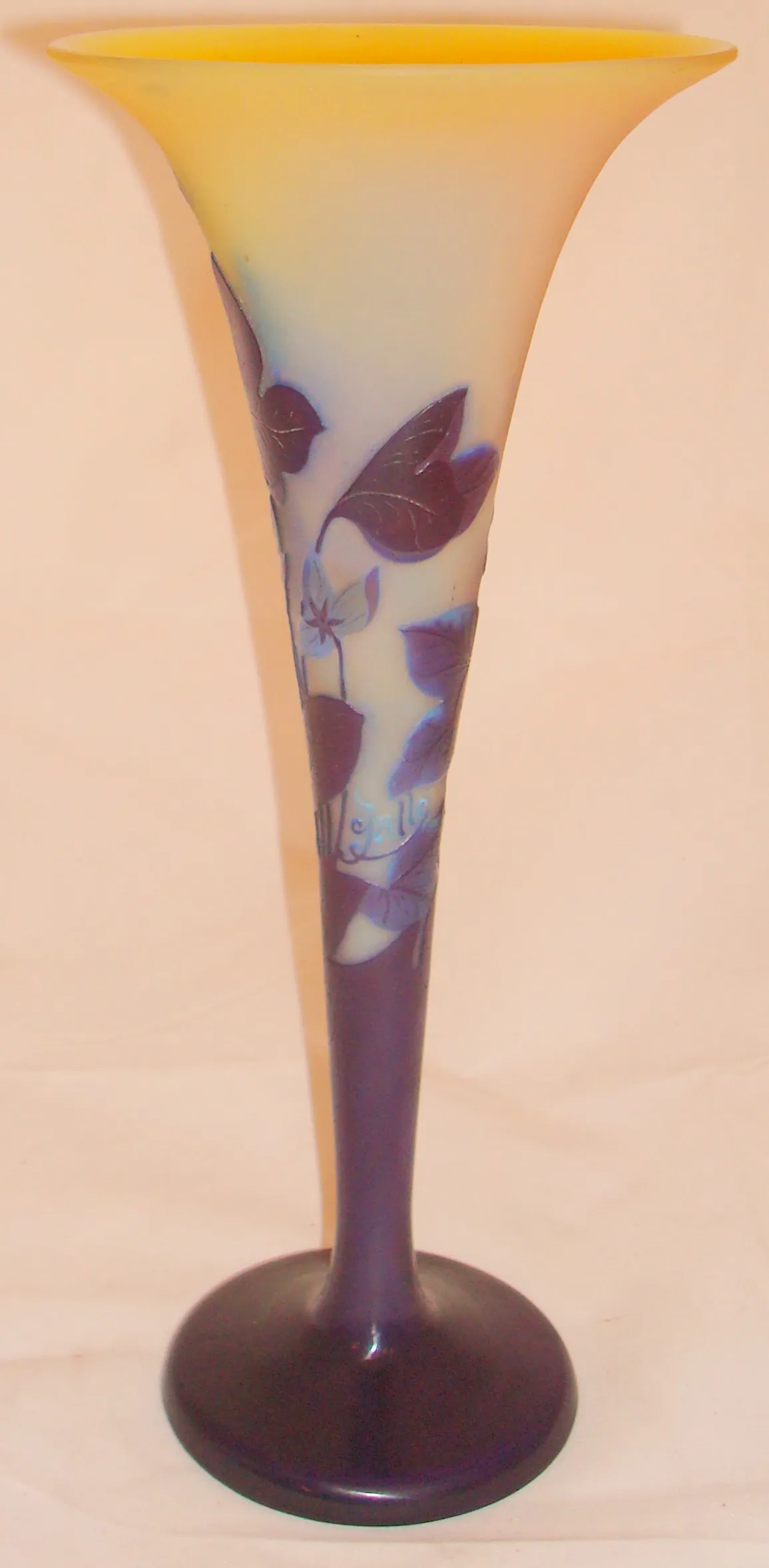 Antique vase with leaf and flower designs in purple hues.