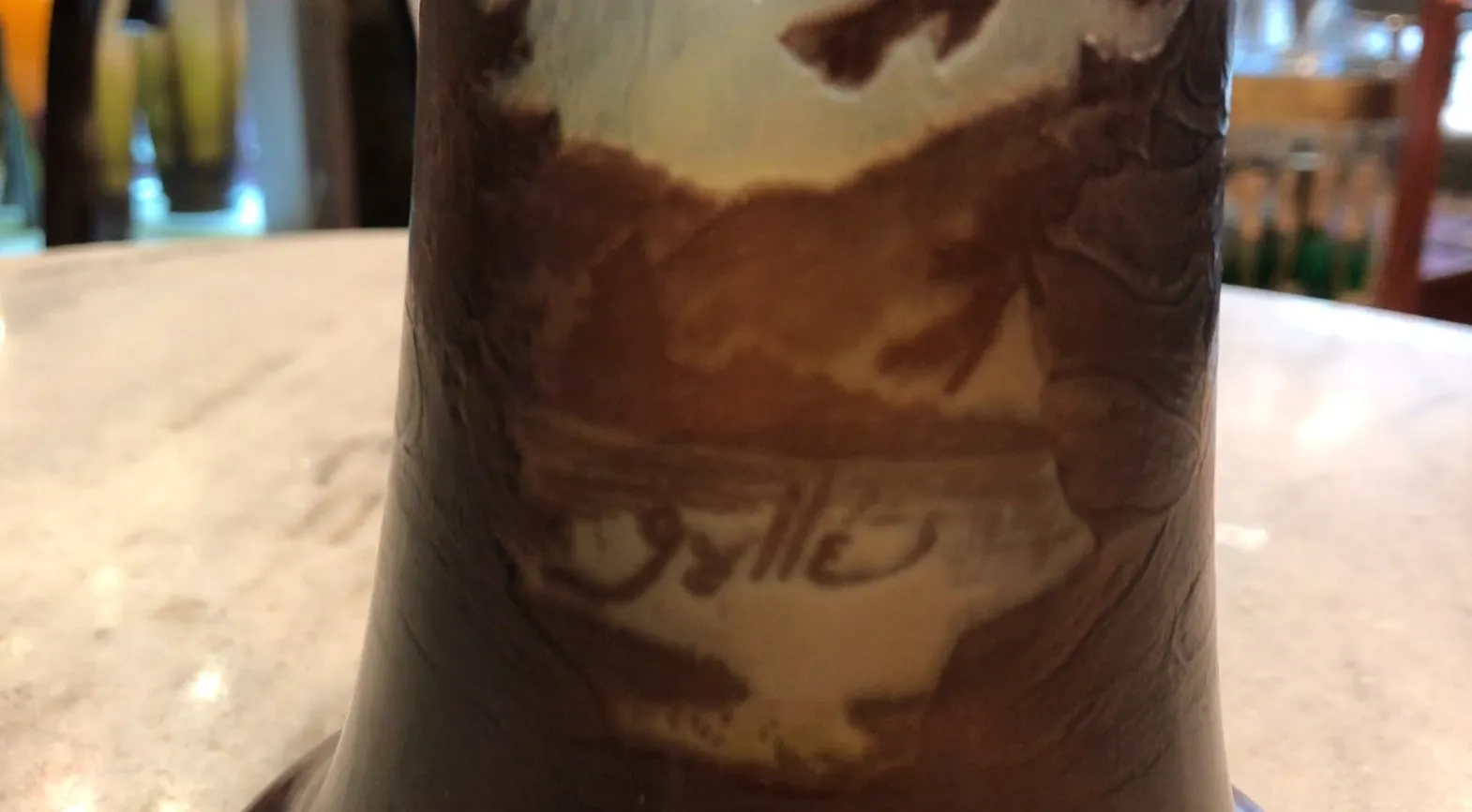 Antique signed Gallé glass with decorative details, natural background.