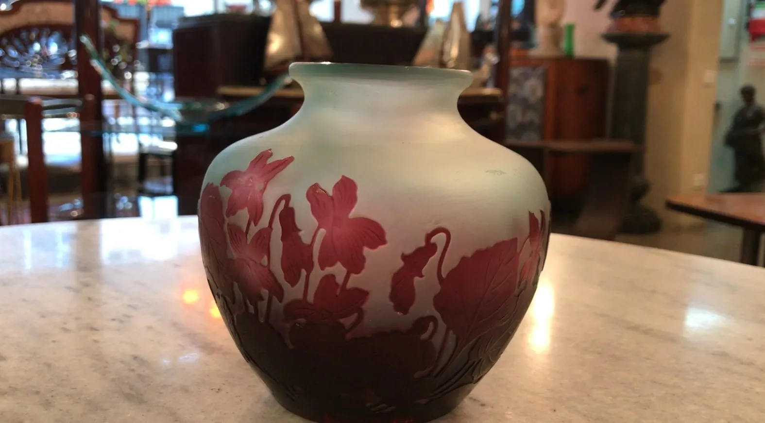 Antique signed glass Gallé with floral design in a warm setting.