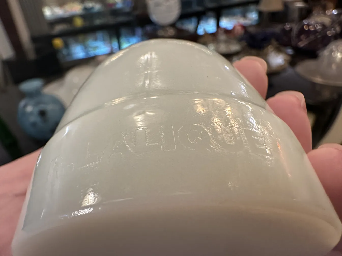 Antique signed glass featuring Lalique inscription, surrounded by collectibles.