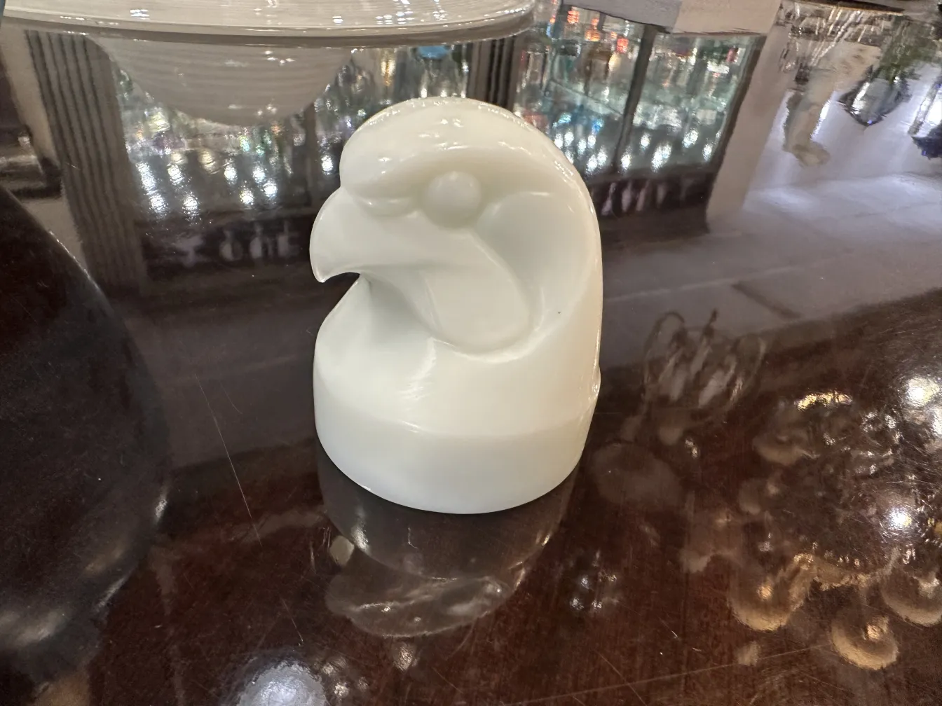 Ancient signed glass sculpture depicting a bird, with a shiny background.