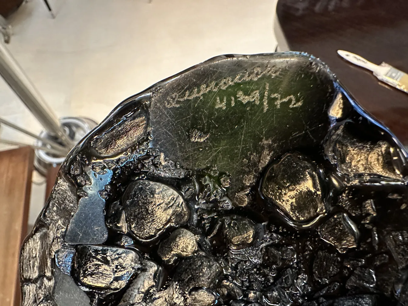 Signed glass with a unique texture and visible details in black.