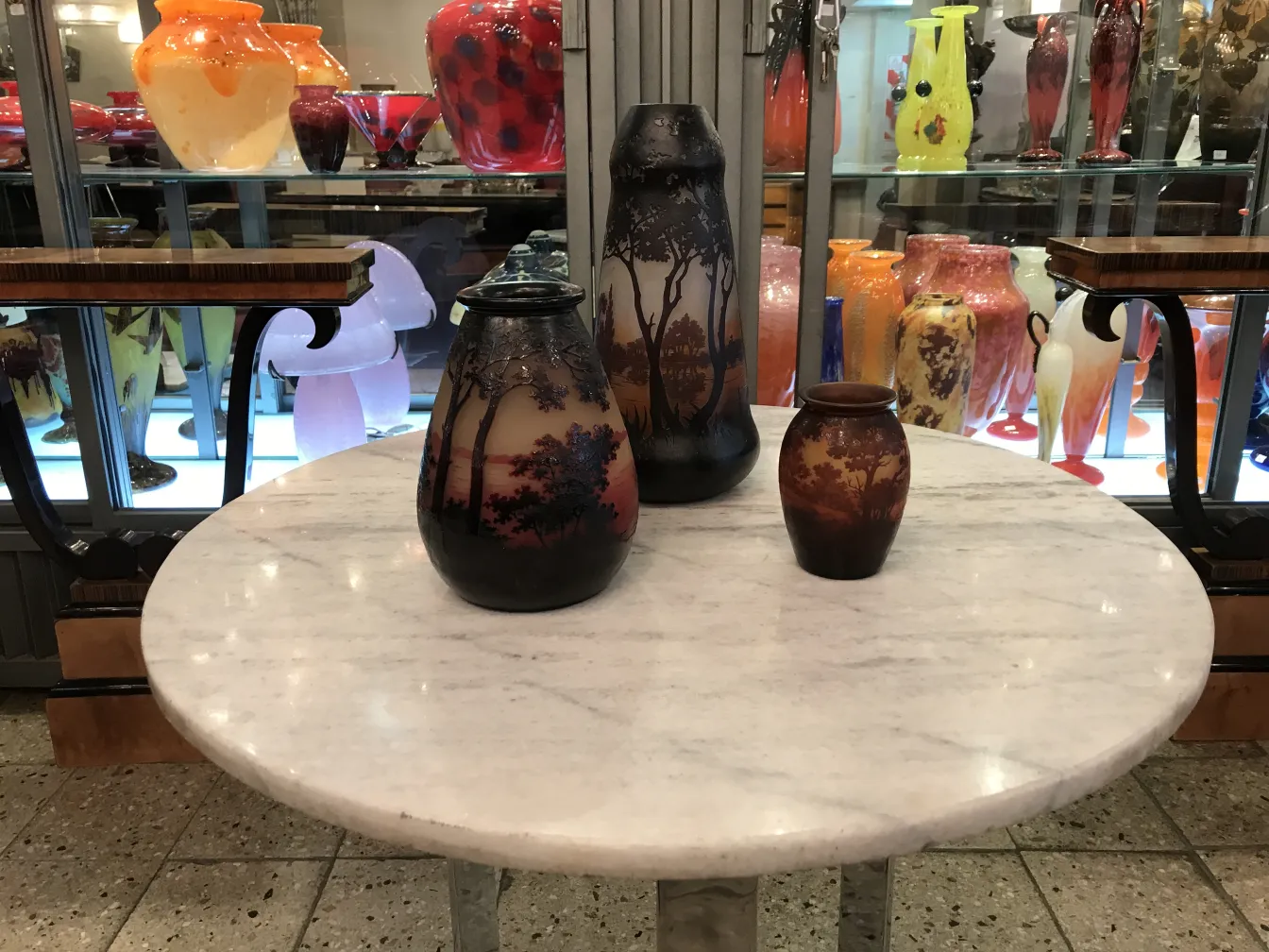 Three signed glass vases by D'Argental on a marble table.