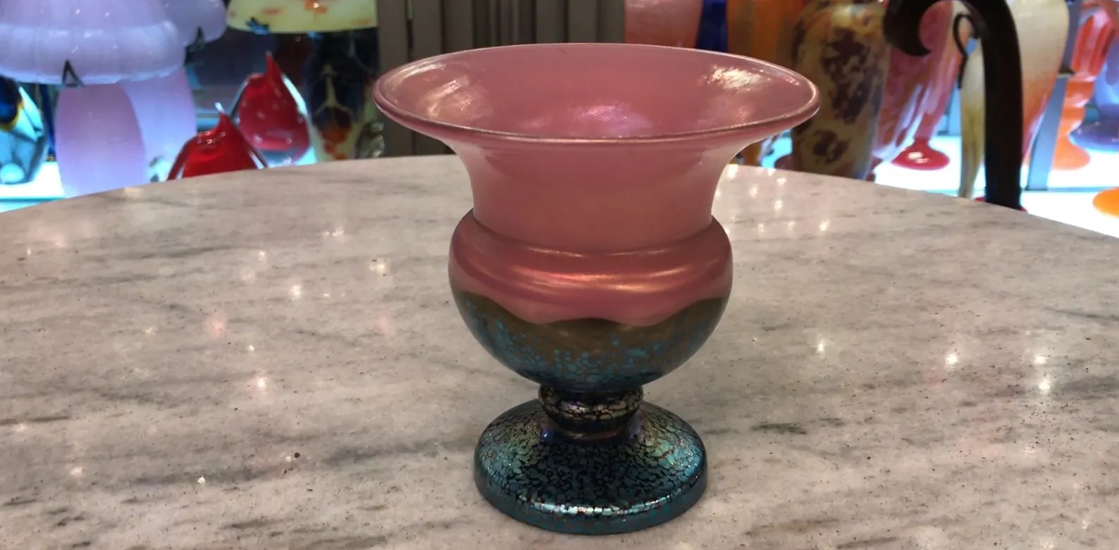 Antique Loetz signed glass in elegant shape with colorful details displayed on marble surface.
