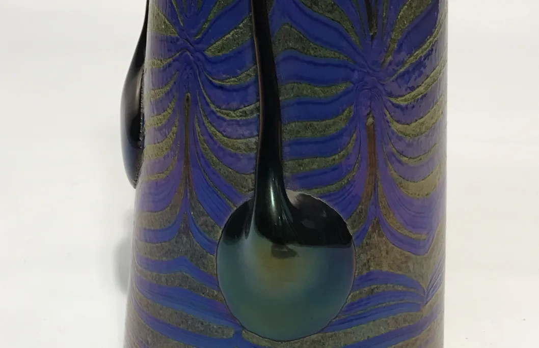 Antique Loetz glass with colorful designs and elegant shapes on a light background.