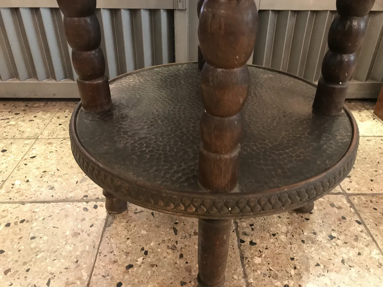 antique small table with round base and sculpted legs in a neutral environment
