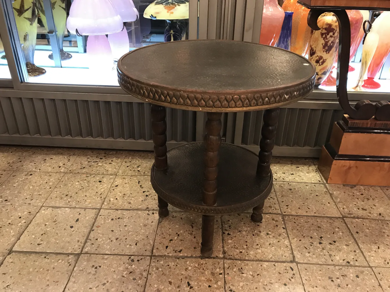 antique small table with two levels, decorative details, in an antique shop
