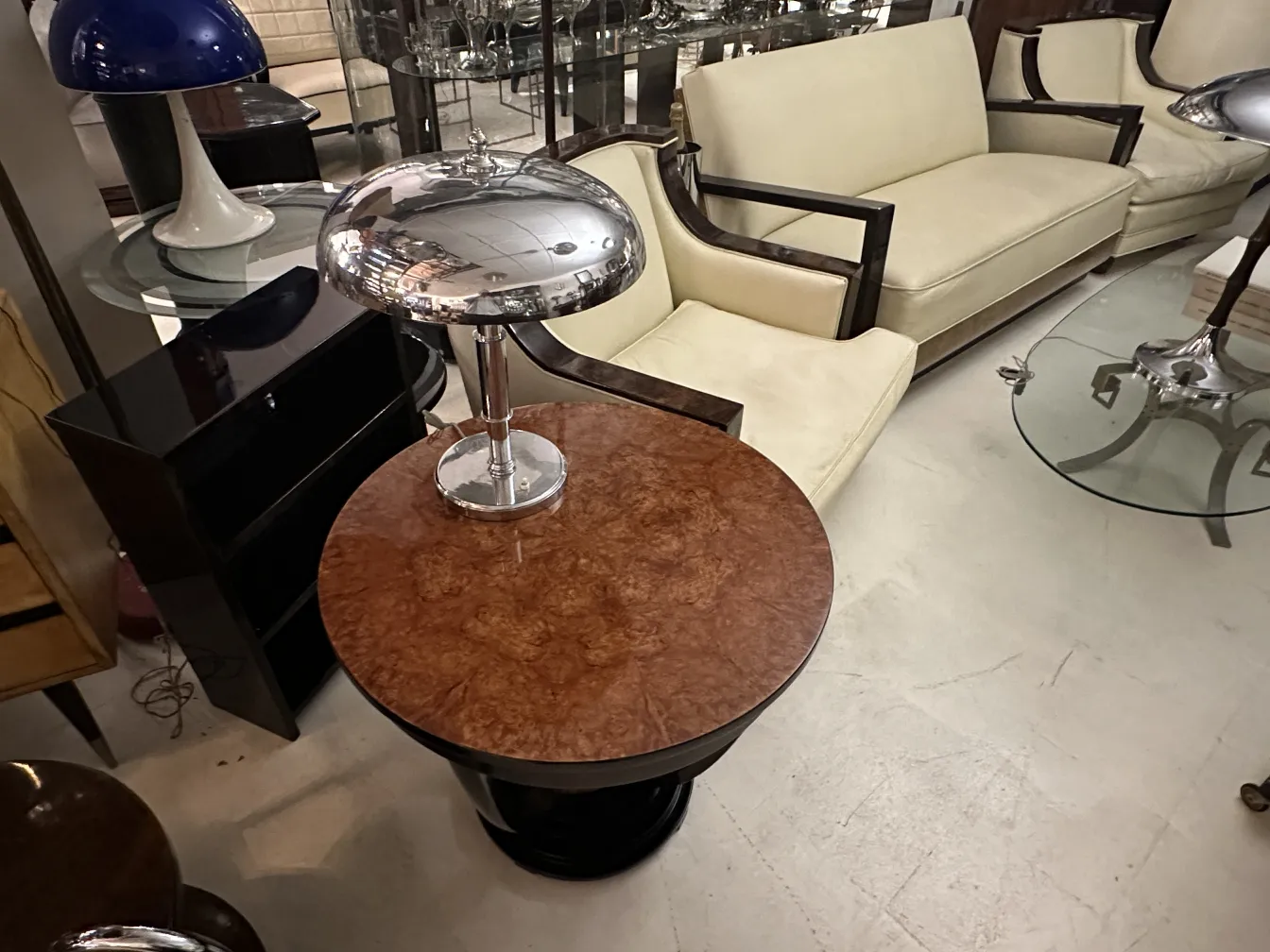 Antique round small table with decorative design on top, surrounded by furniture