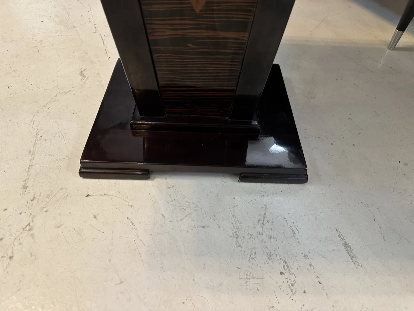 Antique small table with sturdy base and elegant design in a classic setting.